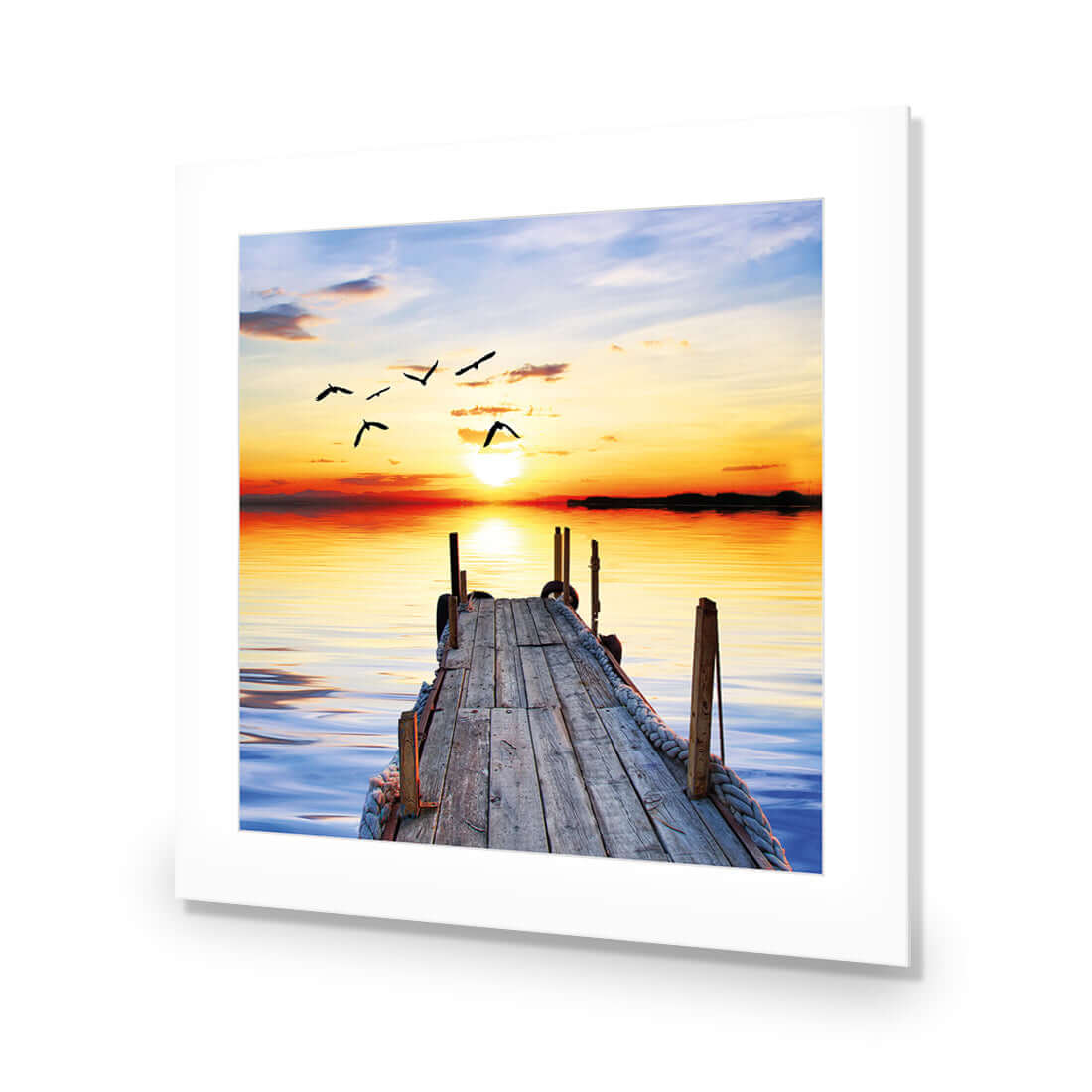 Stretched canvas wall art featuring an abandoned jetty at sunset with birds in the sky, vibrant colors and serene waters.