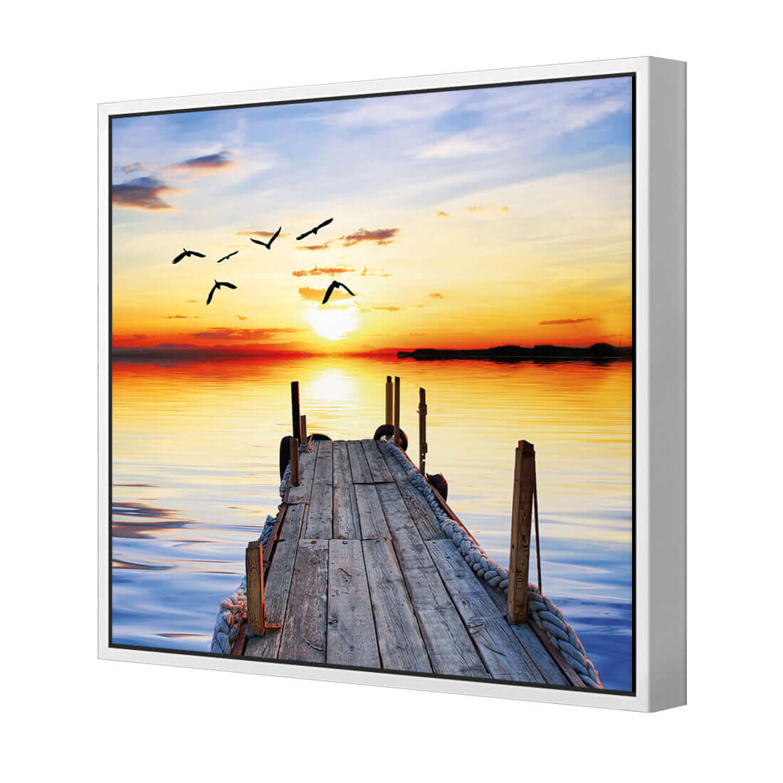 Stretched canvas wall art of an abandoned jetty at sunset with birds flying over the tranquil water.